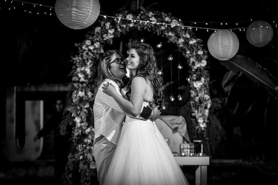 Two brides smiling under the alter.