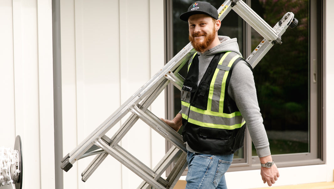 Christmas Light Installer Holding Ladder Safety