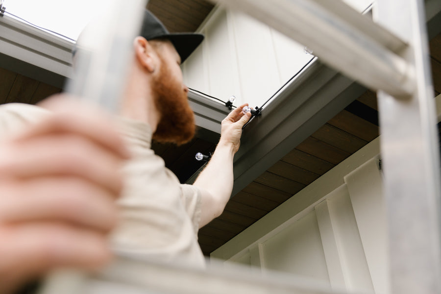 Professional installer on ladder installing lights