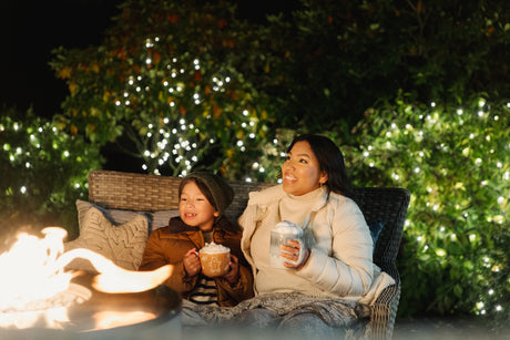 Mother and son enjoy a campfire and Christmas lights