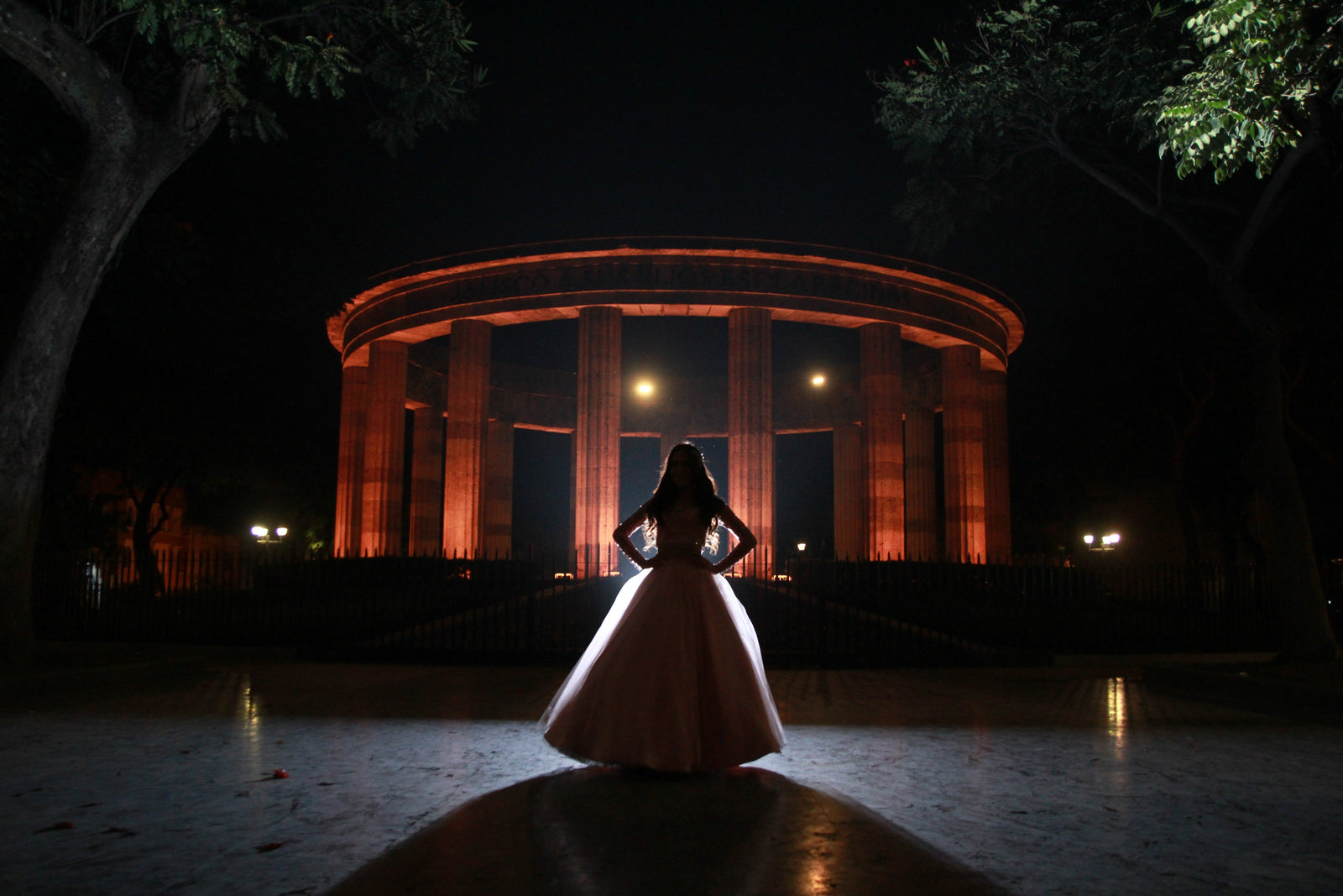 An opera singer performs in a spotlight alone on a large stage